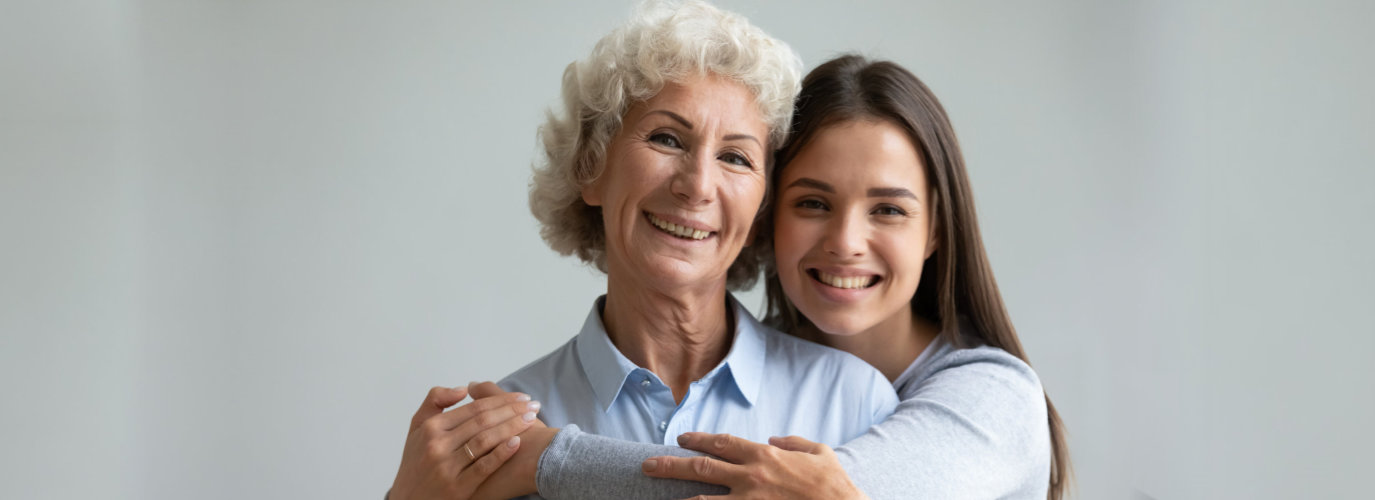 caregiver hugging senior woman indoor